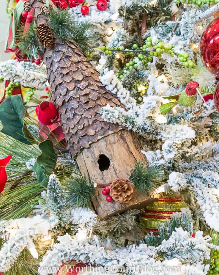 Large birdhouse wired to a Christmas tree.