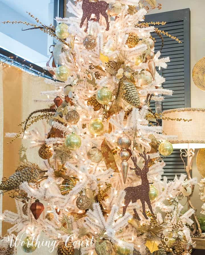Flocked Christmas tree with gold and brown decorations.