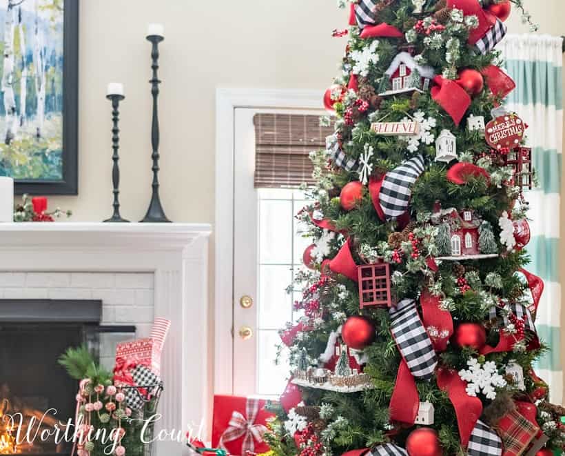 Christmas tree decorated with red, black and white beside the fireplace.