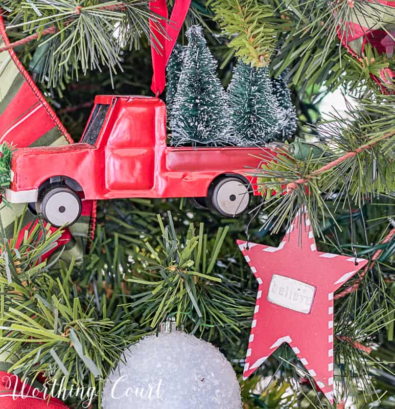 A red toy truck is wired to the Christmas tree.