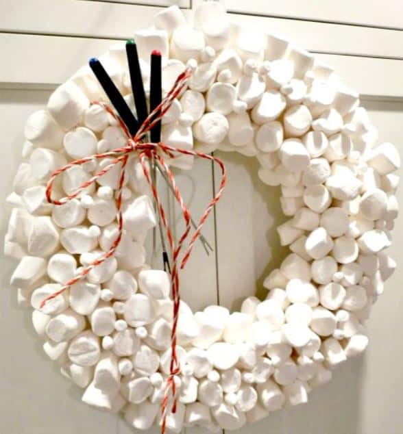 A marshmallow wreath with red and white twine holding fire skewers.