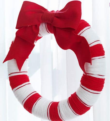 A red and white fabric wreath with a large red bow.