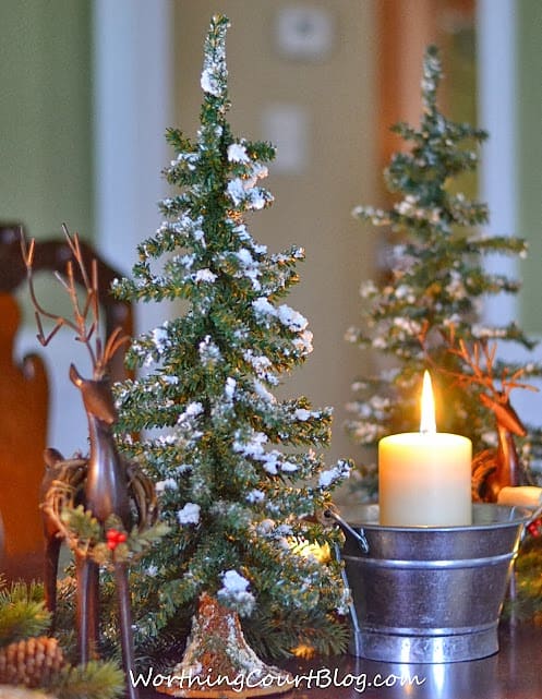 Lit candles beside the Christmas centerpiece.