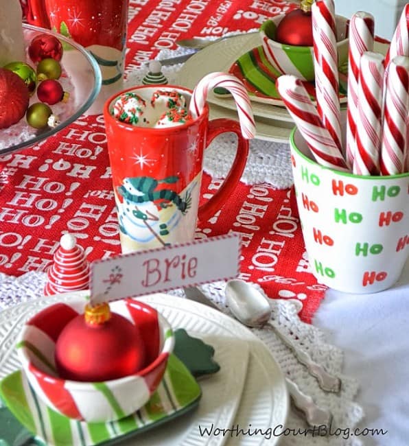 The red and white placards on the table beside candy canes.