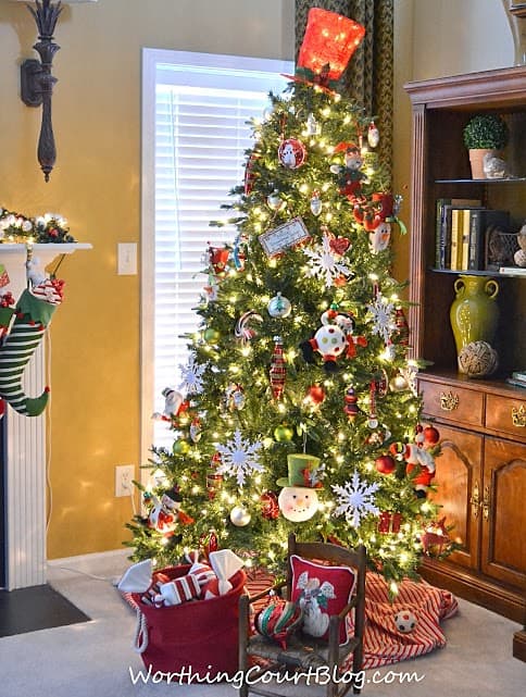 A large Christmas tree in the corner of the living room.