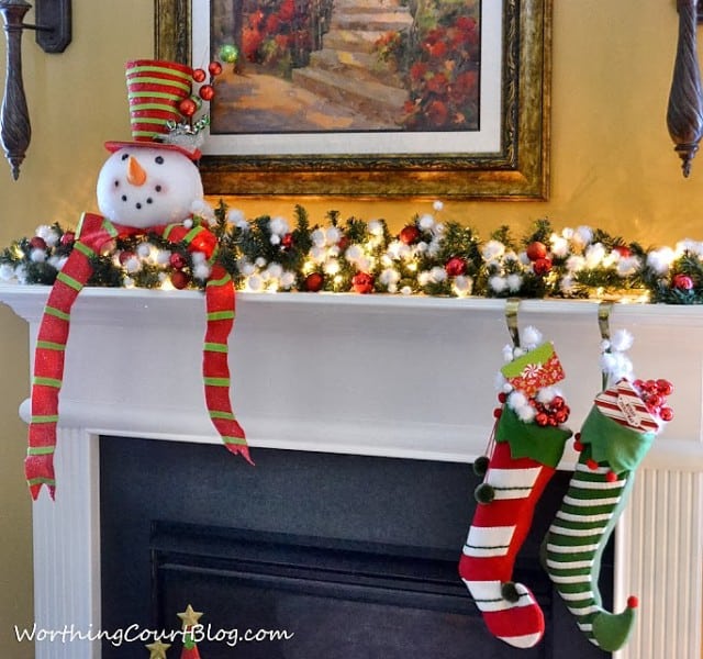 There is a cute snowman on the mantel.