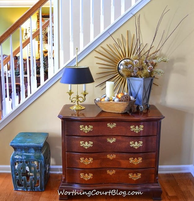 A wooden chest of drawers with holiday items on top.