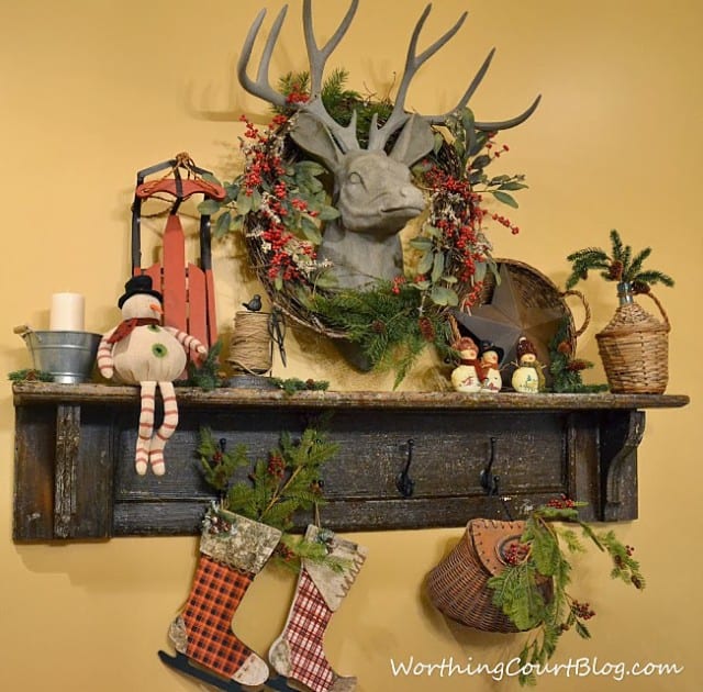  Vintage mantel with faux deer head decorated for Christmas.