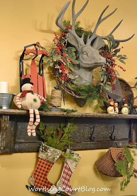  Vintage mantel decorated for Christmas with little snowman and stockings.