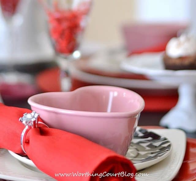 Napkin rings with red napkins.