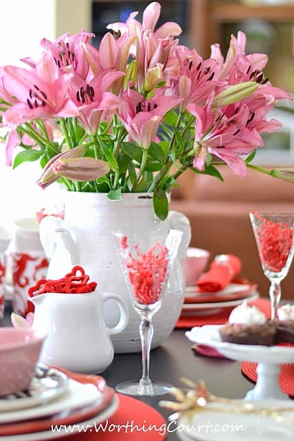 Valentine's Day Tablescape with wine glasses filled with red hearts.