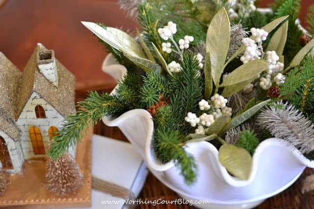 Faux greenery, leaves and berries in a fluted bowl.