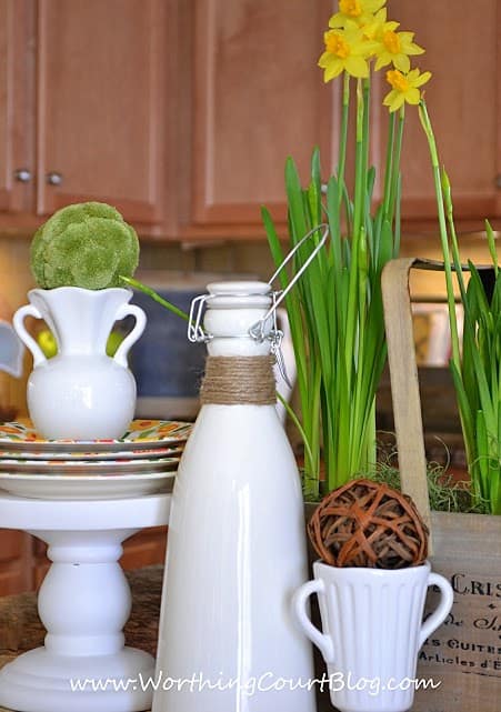 Easy and cheery 5 minute Spring vignette on a kitchen island with daffodils and other natural elements. 
