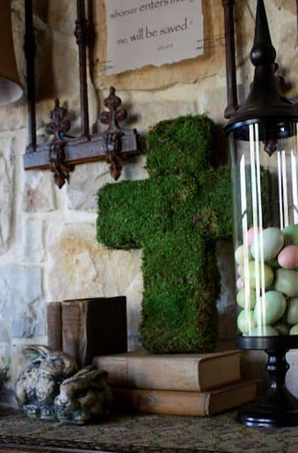 A moss covered cross on antique books.