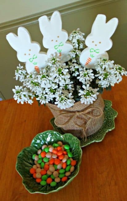 A small dish with candy inside beside white flowers.