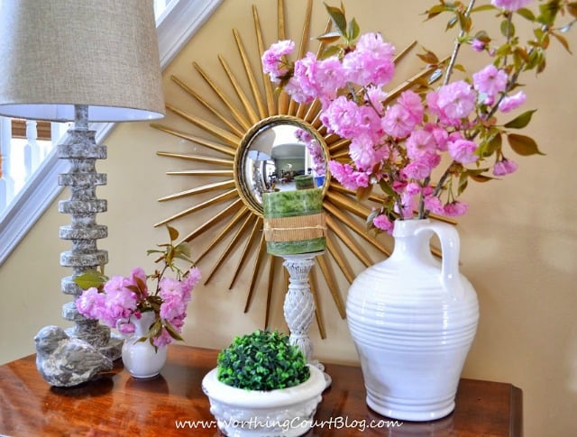 There is a sunburst mirror behind the dresser.