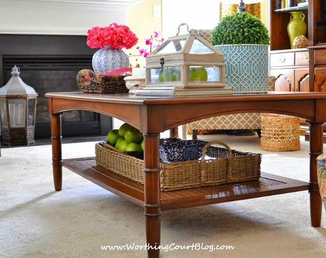 The two leveled coffee table has a tray underneath it to.