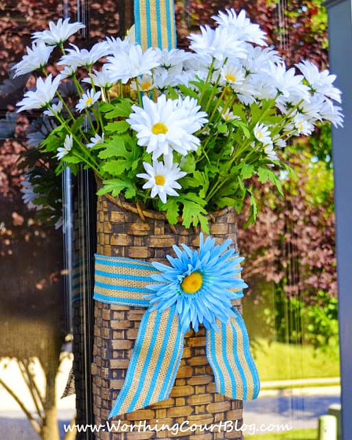 A door basket filled with daisies for summer. A door basket is so versatile. It's easy to simply change what is displayed during the different seasons and for the different holidays.