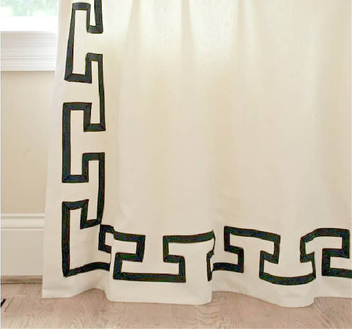 white curtains embellished with grosgrain ribbon in a fretwork pattern