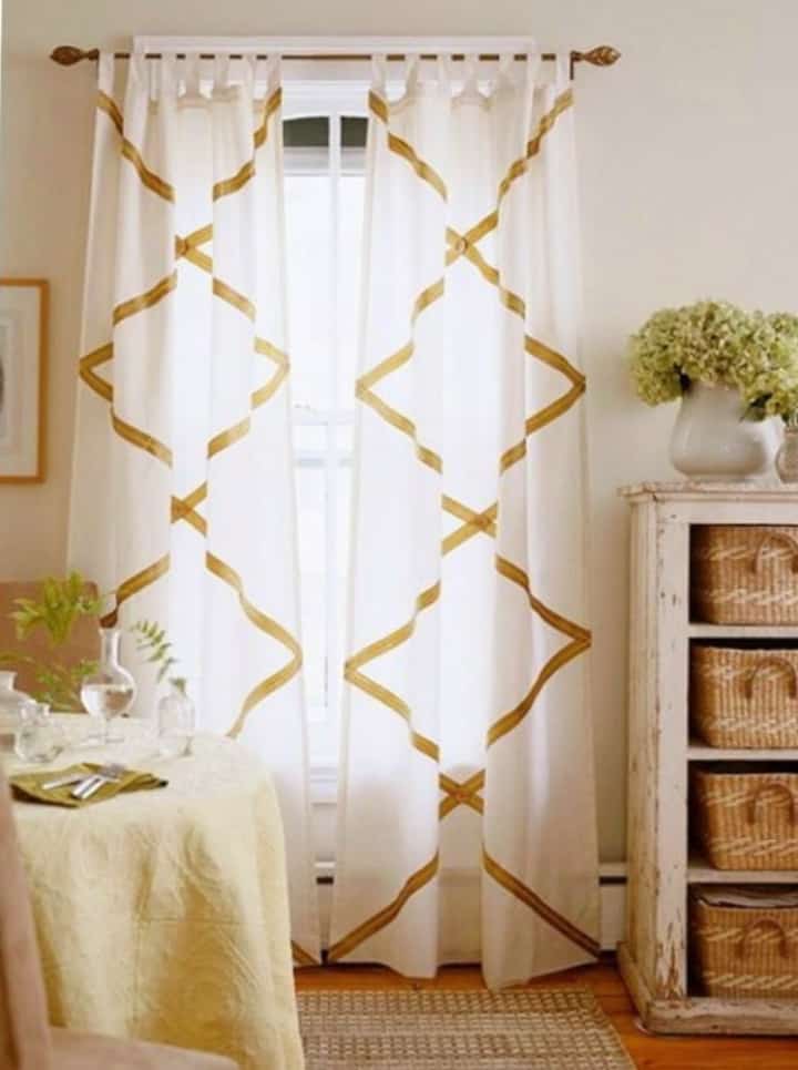 white curtains embellished with grosgrain ribbon in a diamond pattern