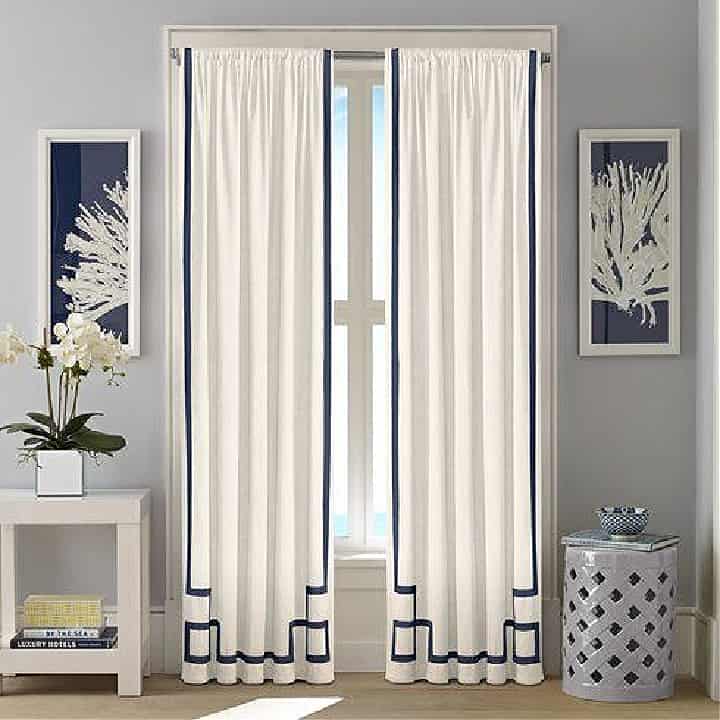 white curtains embellished with grosgrain ribbon in a fretwork pattern