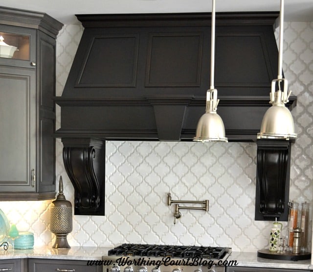 The large, white arabesque shaped tile makes the perfect backdrop for a gorgeous range hood.