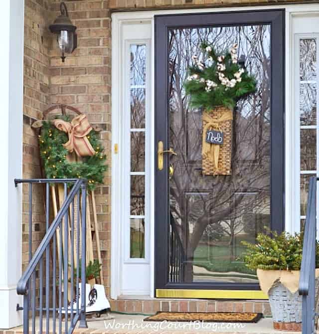 Front porch decorated for Christmas with a vintage sled and ice skates.