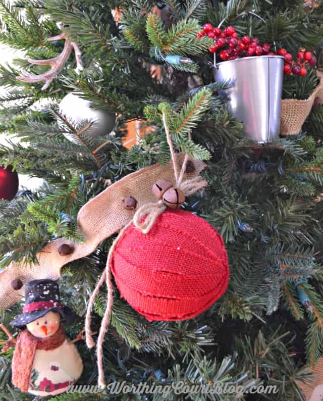 Rustic Christmas ornaments on the tree like a cute snowman and a galvanized pail filled with red berries.