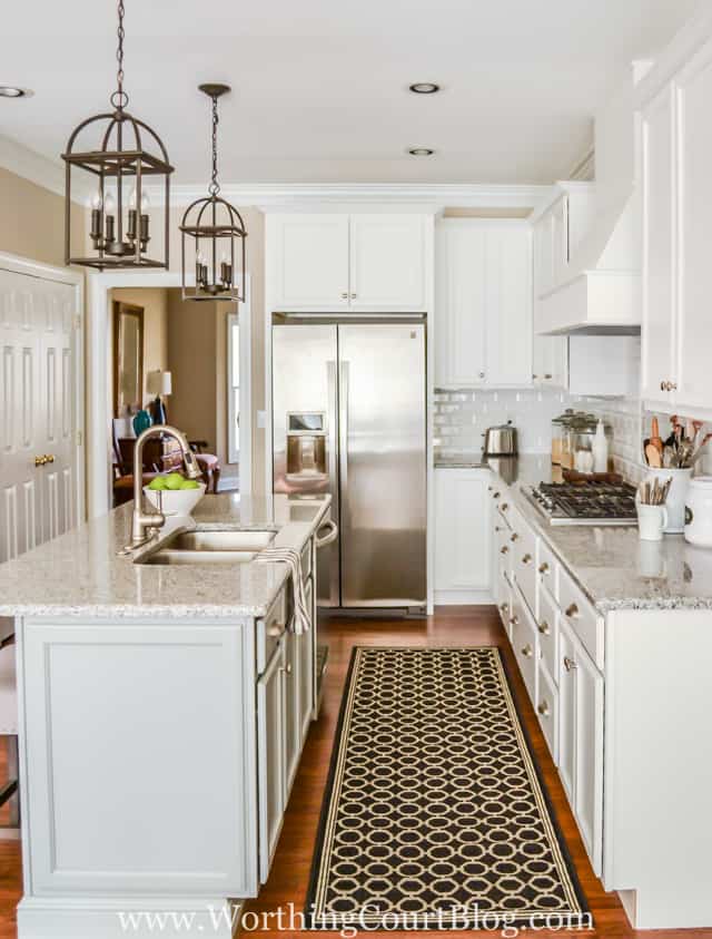 Shiny white kitchen with subway backsplash and basket weave above the stove.