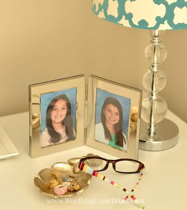 There are pictures of the Granddaughters and eyeglasses on the top of the desk.