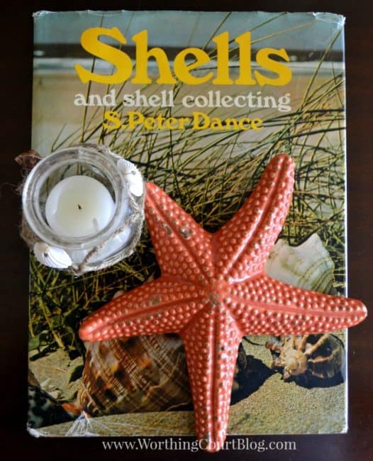A starfish and candle on top of a picture of seashells.