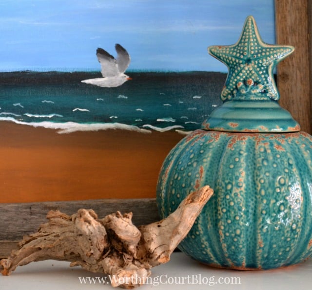 A little turquoise vase with a starfish as a handle.