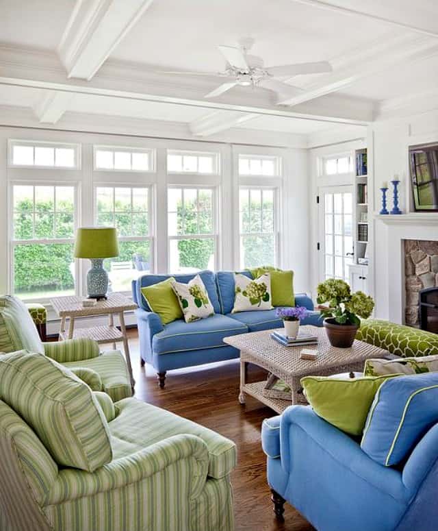 High white ceilings, green two seater couch and green armchairs.