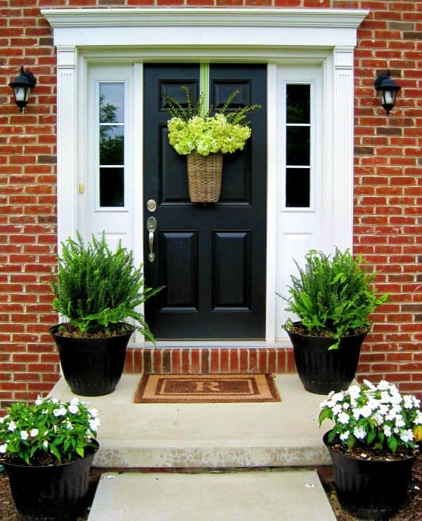 Simple potted plants and a pretty door basket allow the architectural elements of this front door to shine.