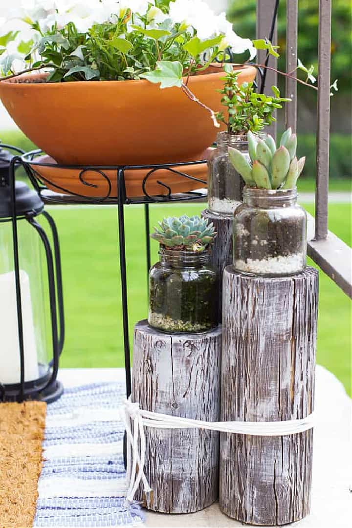 plant stand made with 3 different sized logs tied together with rope