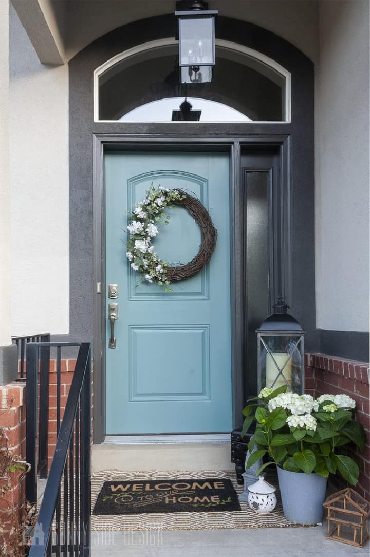 front porch with blue door, gray trim and white siding