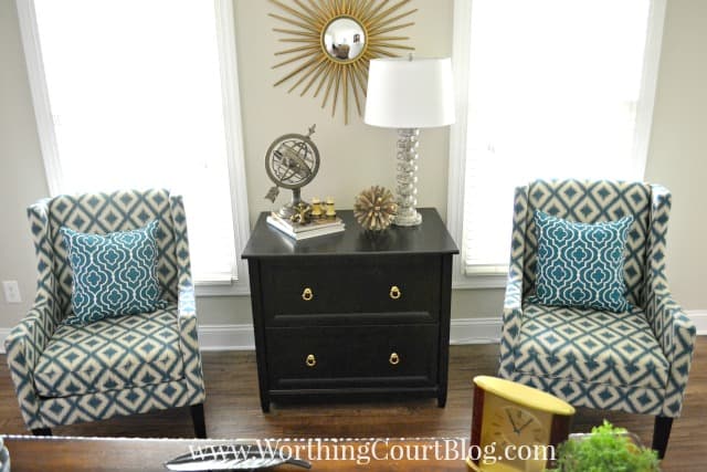 Two armchairs with blue and white throw pillows.