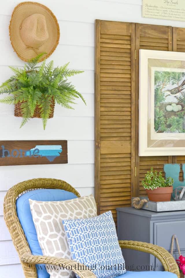 A simple wall collage for outdoors with the gardening hat hanging on the wall.