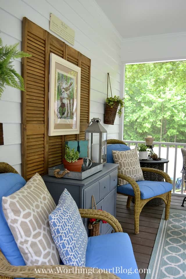 Screen porch decor with blue cushions on the wicker furniture.