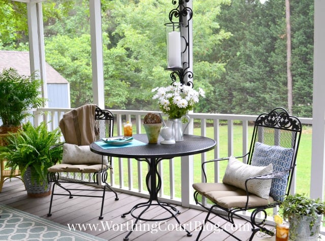 A small wrought iron table and chairs are on the porch.