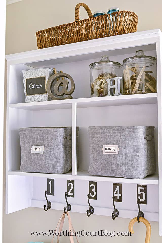 The white shelving unit with a basket on top of it.