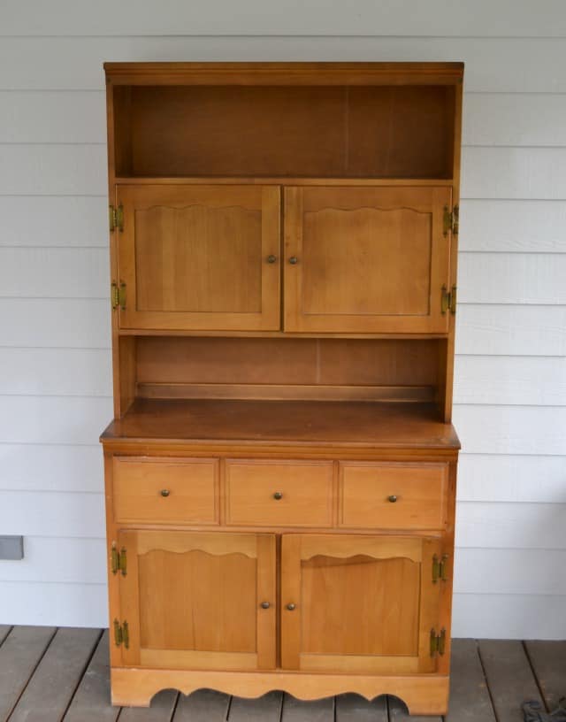 An old wooden hutch outside on the porch.