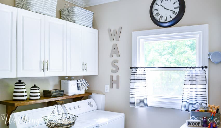 DIY shelf behind washer and dryer to hold laundry supplies.