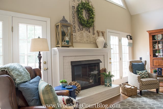 Two armchairs flank the fireplace with throw pillows on them.