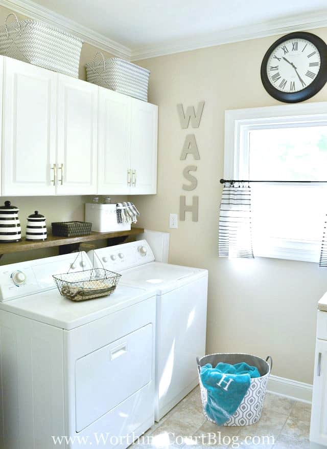 Laundry room with white cabinets and white appliances.