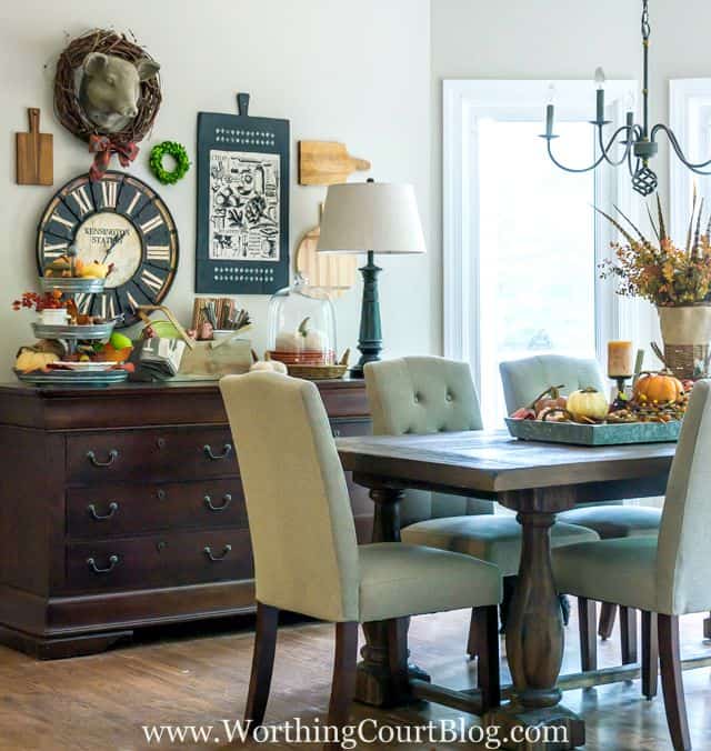 The dining room table with a fall centerpiece in the middle of the table.