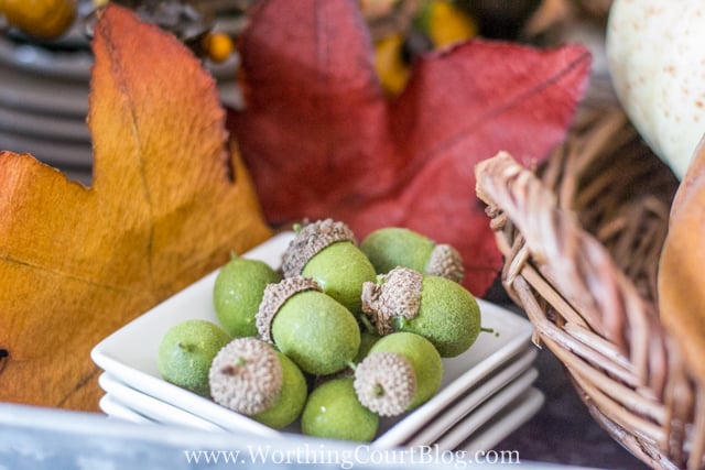 Small decorative acorns in a white dish.