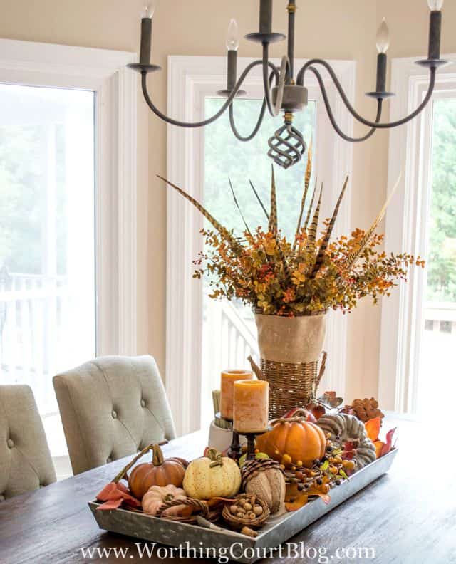 A tray on a dining room table filled with fall decor.