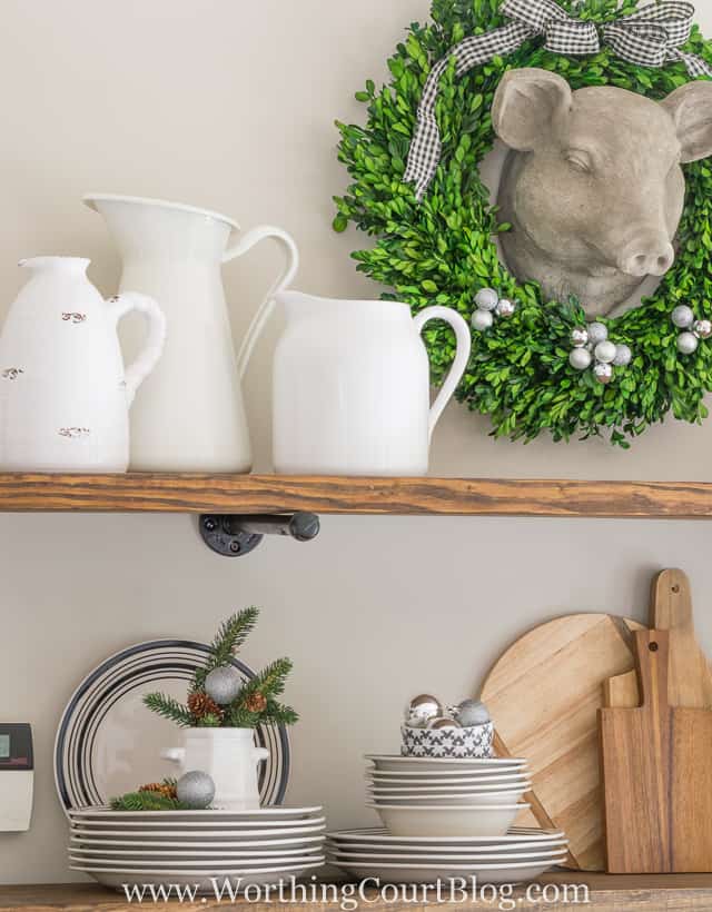 Rustic Farmhouse Kitchen Shelves Decorated For Christmas with a pigs ceramic head and a wreath around it.