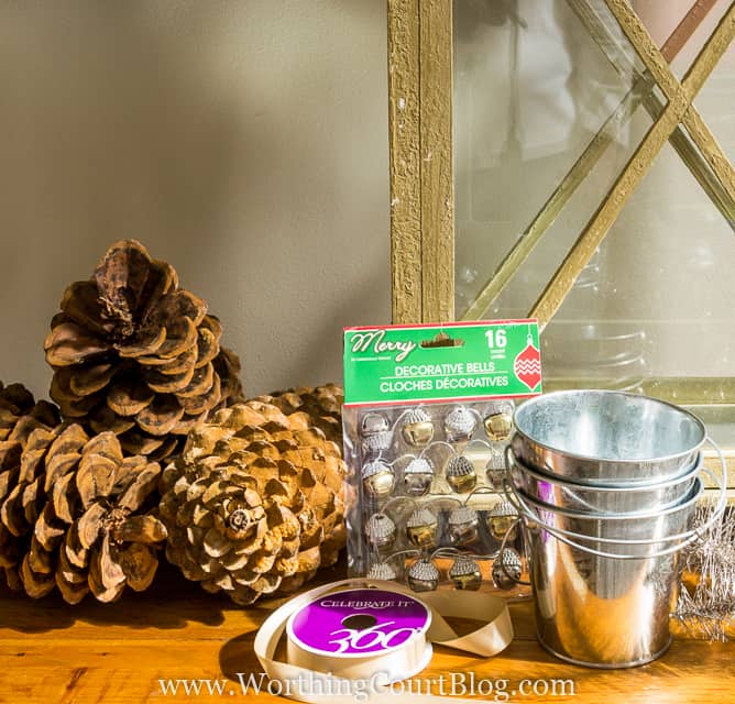 Pine cones, ribbon, little silver buckets, and bells on the table.